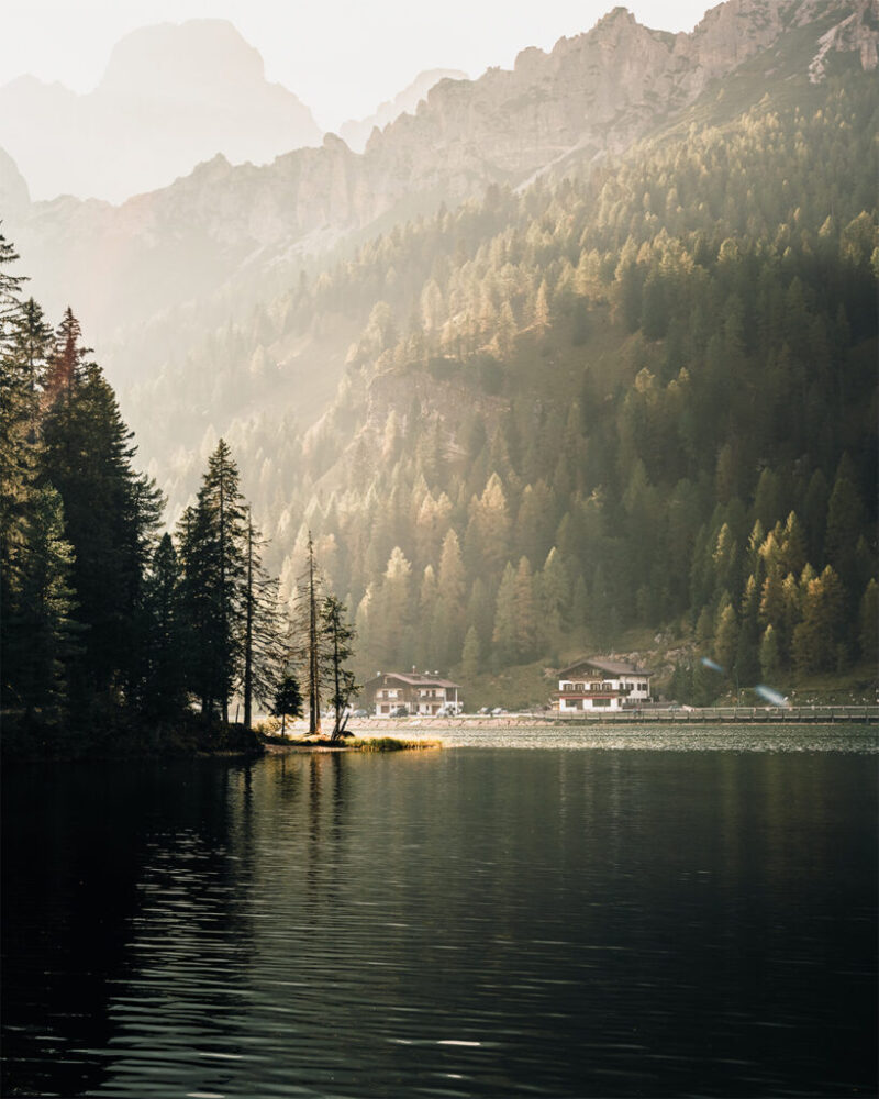 lake with houses and mountains in background