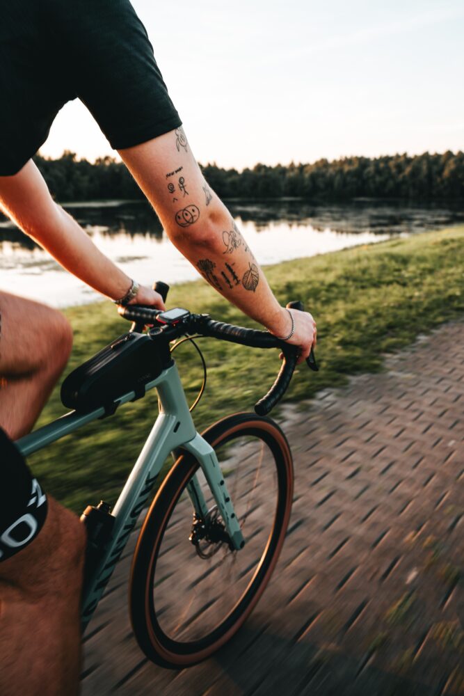 tattoed arm from a man on gravel bike riding fast