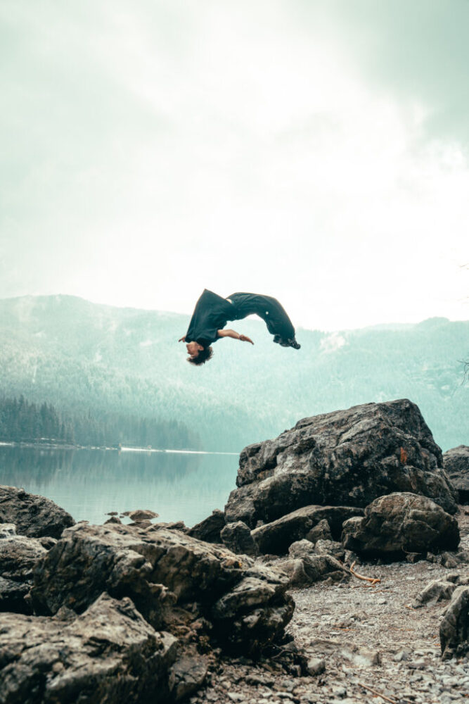 man doing backflip on rock
